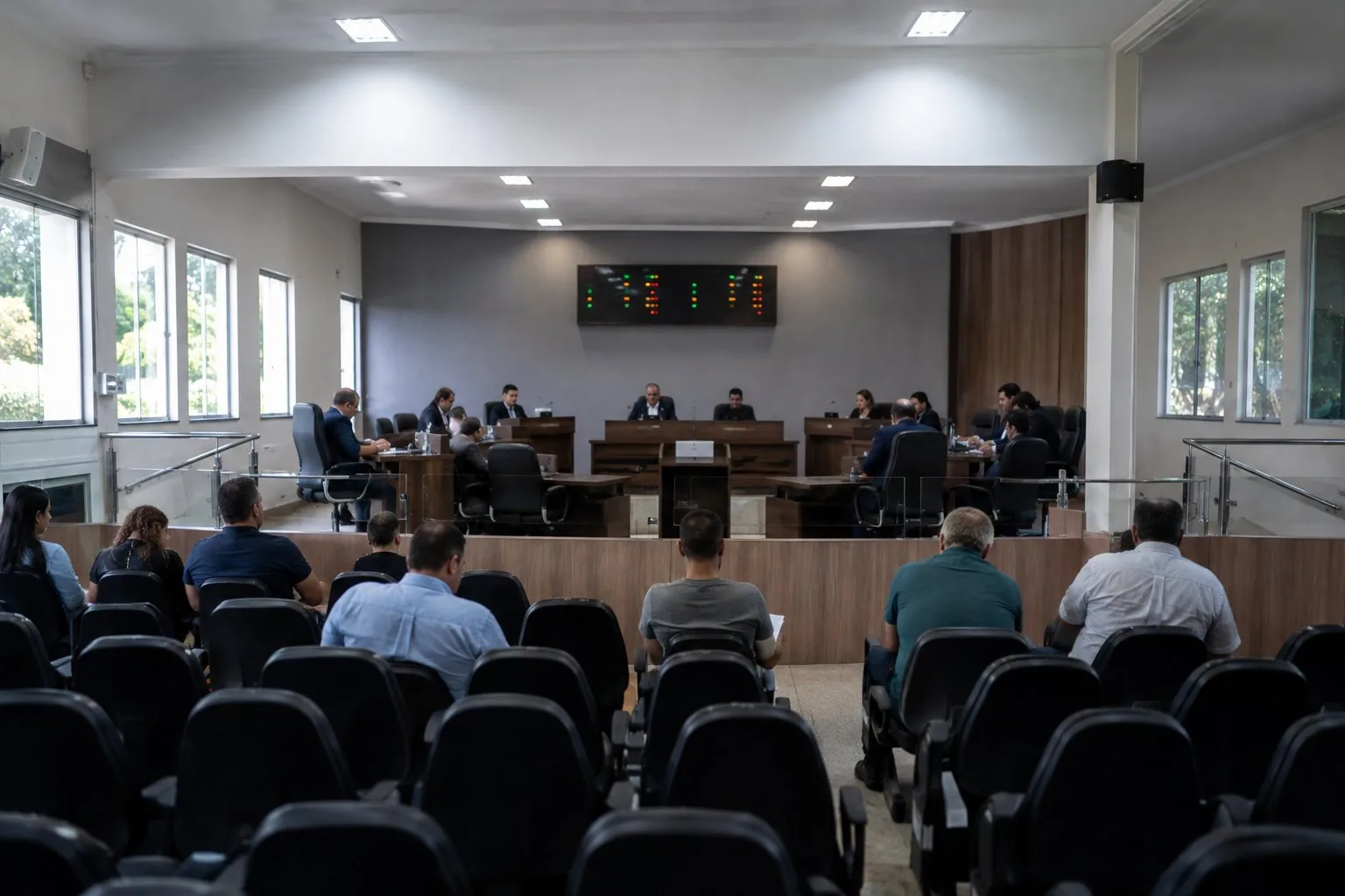 Plenário de câmara municipal durante sessão, com vereadores em suas bancadas
